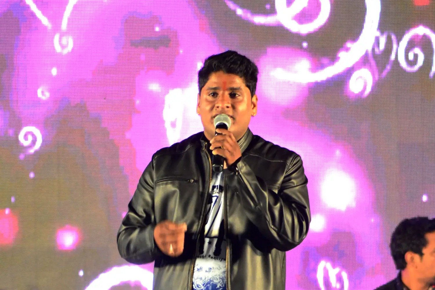 Balloon arch in orange, black, and white colors framing an ITT logo board lit with warm lights